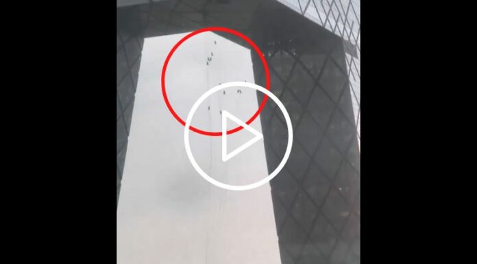 Trabajadores colgados de un edificio en China