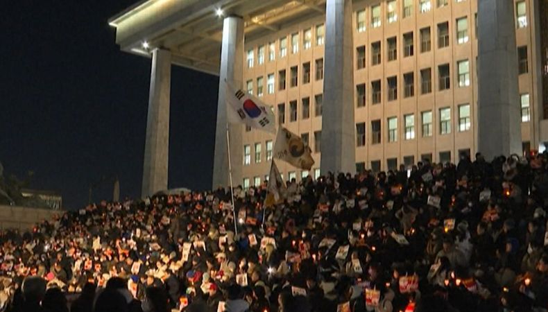 En Corea del Sur, miles de ciudadanos marcharon al Parlamento para apoyar la decisión de la oposición de exigir la renuncia del presidente.